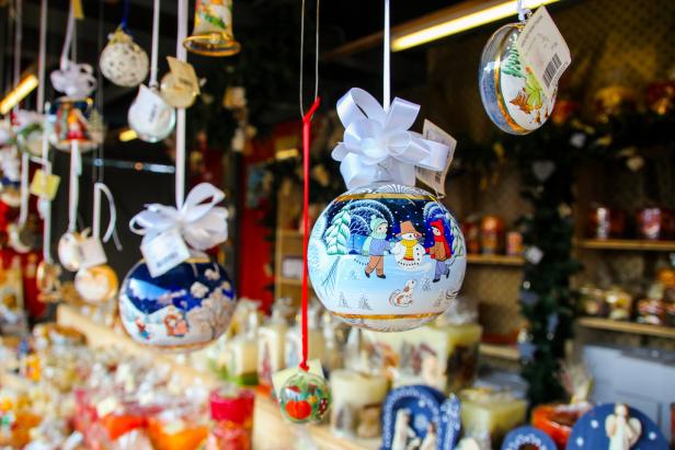 Auf einem Weihnachtsmarkt hängen bemalte Christbaumkugeln mit Wintermotiven.