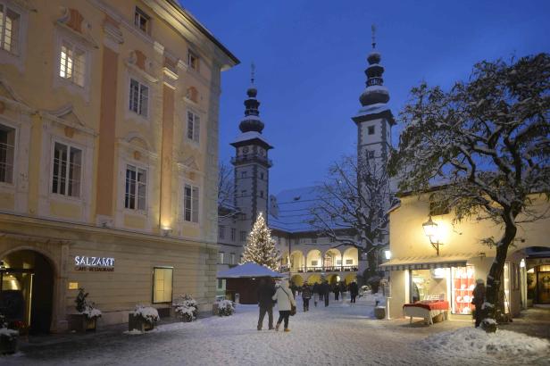 Ein verschneiter Platz in Gmunden mit Blick auf das Rathaus und einen Weihnachtsbaum.