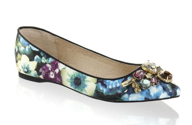 Ein Ballerina-Schuh mit Blumenmuster und Schmucksteinen verziert.