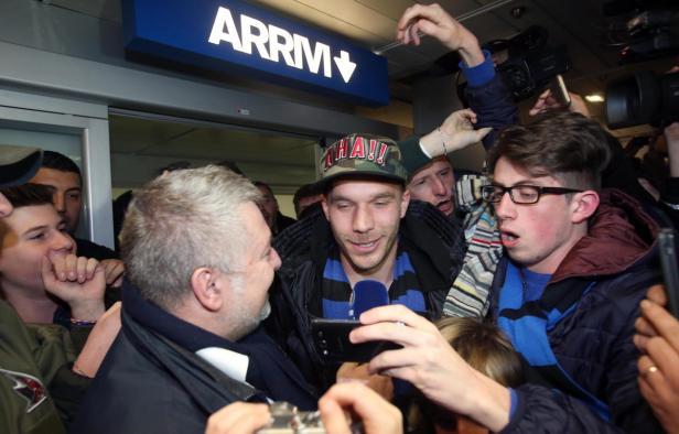 Eine Menschenmenge umringt eine Person mit einer Kappe mit der Aufschrift „AHA!!“.