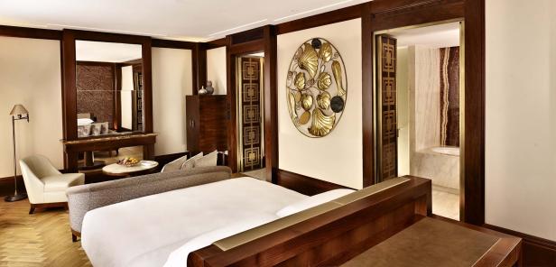Ein luxuriöses Hotelzimmer mit Holzelementen und einem goldenen Wandornament.