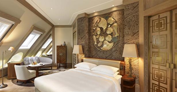 Ein luxuriöses Schlafzimmer mit einem großen Bett und einem goldenen Wandornament.