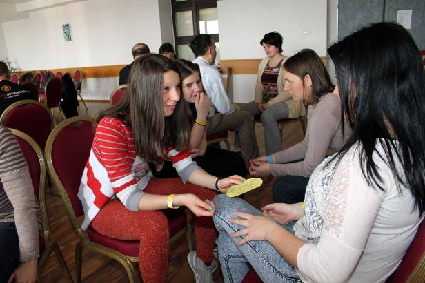 Mehrere junge Frauen sitzen in einem Raum im Kreis und unterhalten sich.