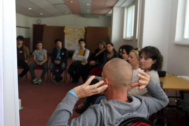 Eine Gruppe von Menschen sitzt in einem Raum und hört aufmerksam zu.