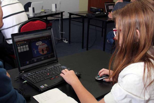 Eine junge Frau arbeitet an einem Laptop mit einer Grafik auf dem Bildschirm.