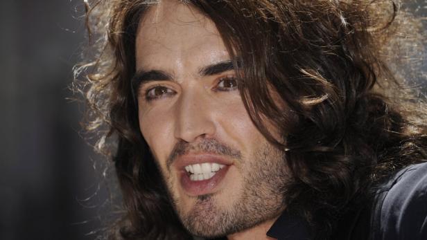 Porträt von Russell Brand mit offenem Mund und braunen, lockigen Haaren.