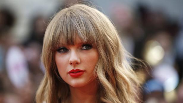 Ein Porträt von Taylor Swift mit blonden Haaren und rotem Lippenstift.