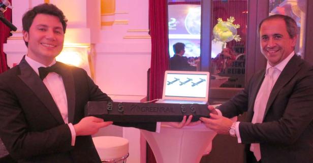 Zwei Männer in Anzügen präsentieren ein „Greenrail“-Produkt.