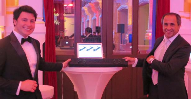 Zwei Männer im Anzug präsentieren ein „Greenrail“-Produkt auf einem Tisch.