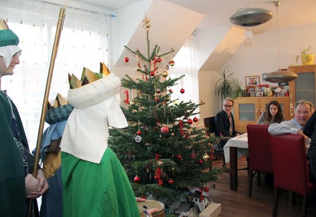 Sternsinger besuchen eine Familie am Weihnachtstag.