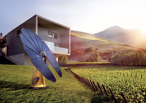 Eine „Smartflower“-Solarenergieanlage steht vor einem modernen Haus in einer ländlichen Umgebung.