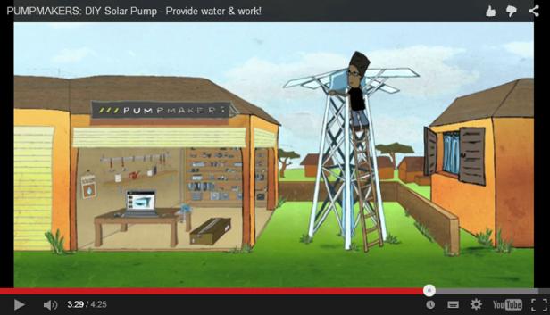 Ein Mann montiert eine Solarpumpe auf einem Turm neben einem „Pumpmakers“-Gebäude.