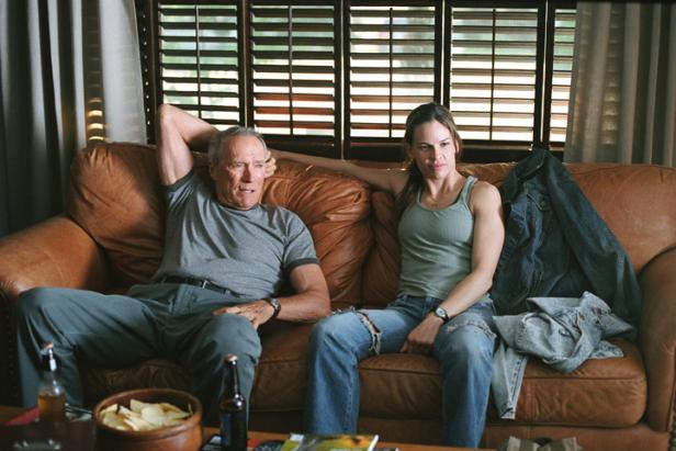 Clint Eastwood und Hilary Swank sitzen auf einer Couch, vermutlich während Dreharbeiten zu „Million Dollar Baby“.