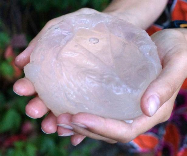 Eine Person hält eine große, durchsichtige Kugel in ihren Händen.