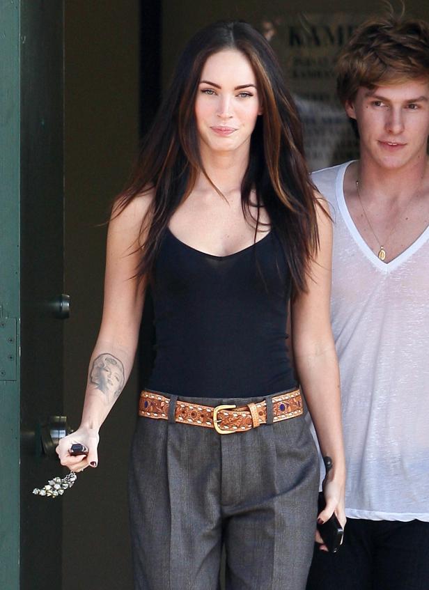 Megan Fox mit Tattoo von Marilyn Monroe auf dem Arm, zusammen mit einem Mann.
