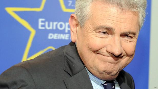 Jean-Claude Juncker lächelt vor einem Hintergrund mit Europasternen.