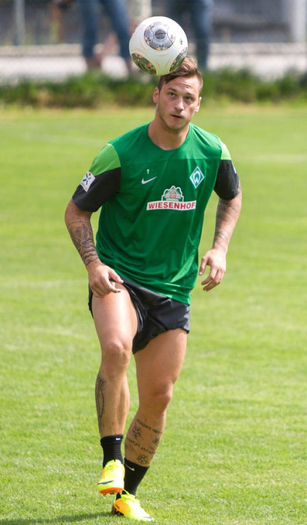 Ein Fußballspieler balanciert einen Ball auf dem Kopf.