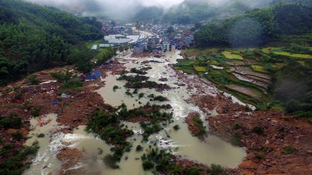 Eine Überschwemmung hat ein Dorf und Ackerland verwüstet.