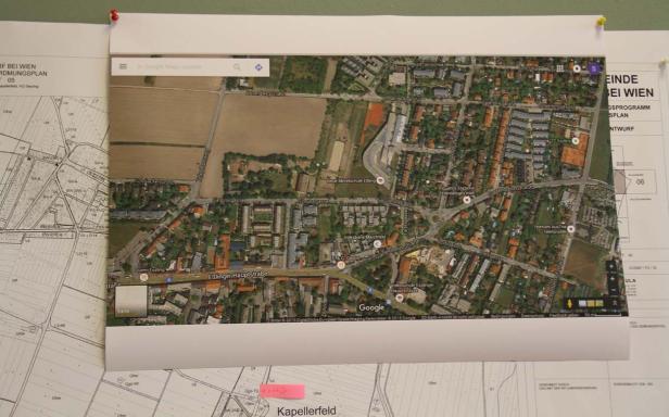 Ein ausgedruckter Google Maps-Ausschnitt von Eßling, Wien, hängt an einer Wand.