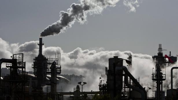 Rauch steigt aus den Schornsteinen einer Industrieanlage auf.