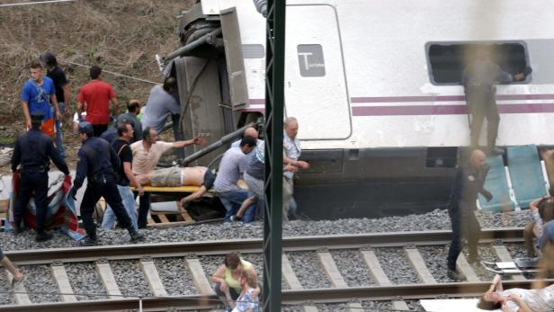 Nach einem Zugunglück werden Verletzte auf einer Bahre abtransportiert.