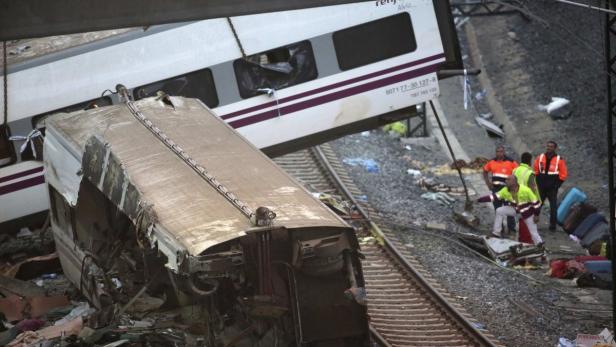 Ein schwer beschädigter Zug nach einem Unfall, mit Rettungskräften vor Ort.