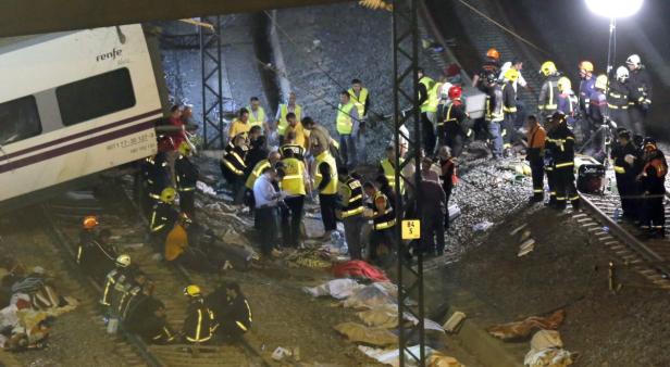 Ein verunglückter Zug der spanischen Bahngesellschaft Renfe liegt neben den Gleisen, umgeben von Rettungskräften.