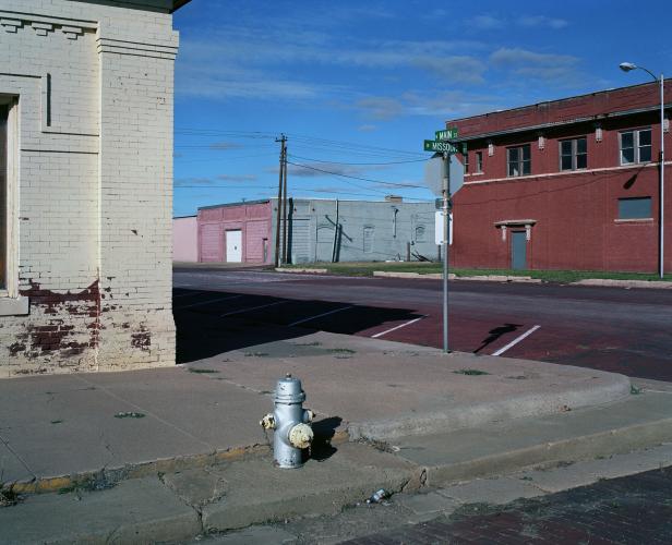 Eine silberne Hydrant steht an einer Straßenecke in einer amerikanischen Kleinstadt.