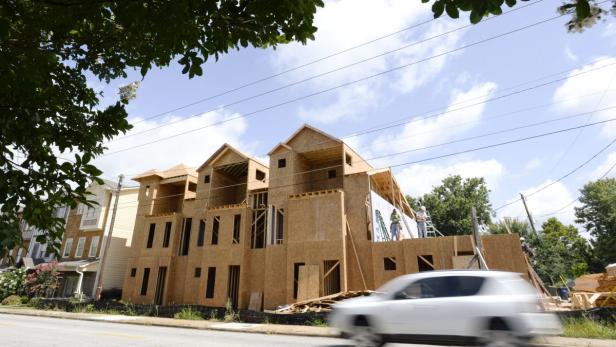 Im Bau befindliche Mehrfamilienhäuser neben bestehenden Wohnhäusern.
