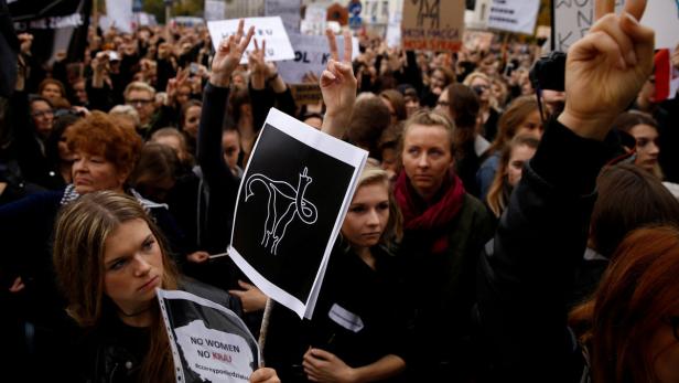 Eine Menschenmenge demonstriert mit Schildern für Frauenrechte.