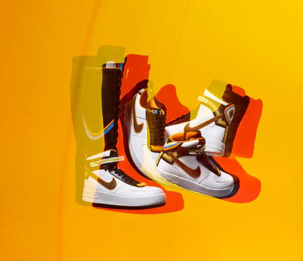 Mehrere weiße Nike Air Force 1-Schuhe auf einem gelben Hintergrund.