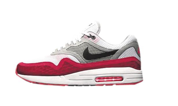 Ein rot-weiß-grauer Nike Air Max 1 Turnschuh mit schwarzem Logo.