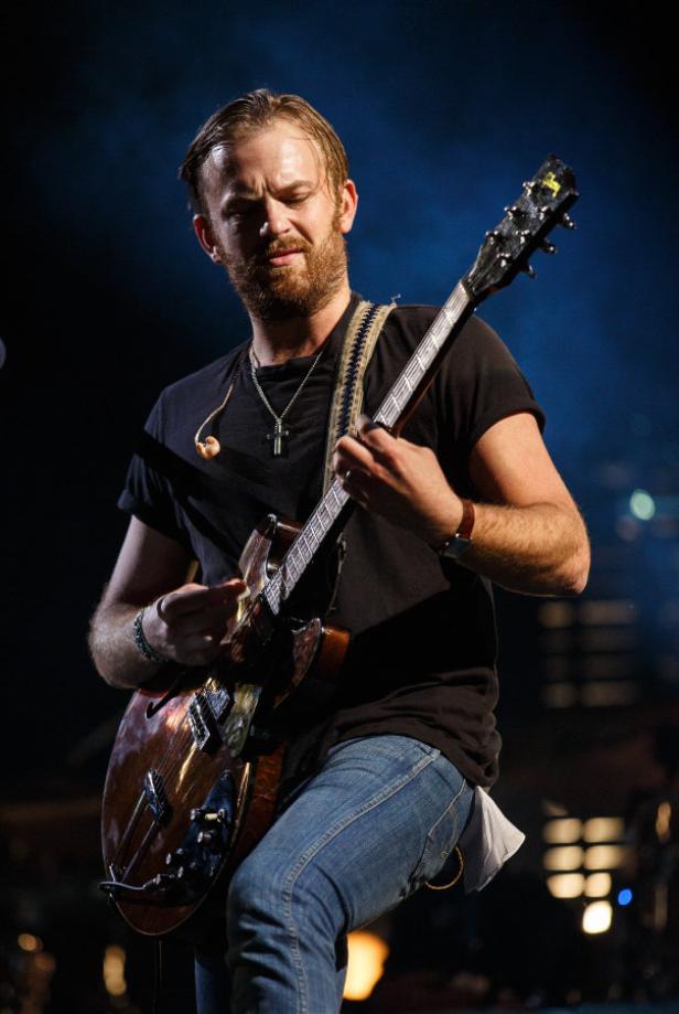 Ein Mann mit Bart spielt auf einer E-Gitarre.
