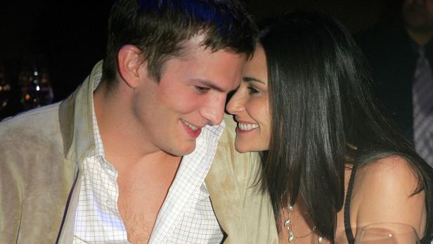 Ashton Kutcher und Demi Moore lächeln sich an.