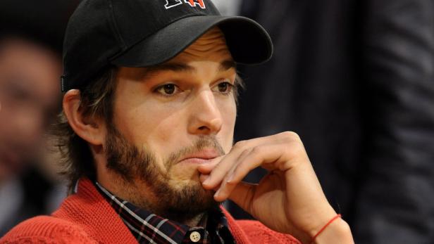 Ashton Kutcher mit Bart und Baseballkappe wirkt nachdenklich.