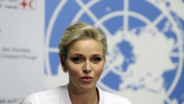 Fürstin Charlène von Monaco vor einem Hintergrund mit einer Weltkarte.