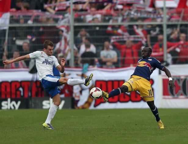 Zwei Fußballspieler kämpfen um den Ball während eines Fußballspiels.