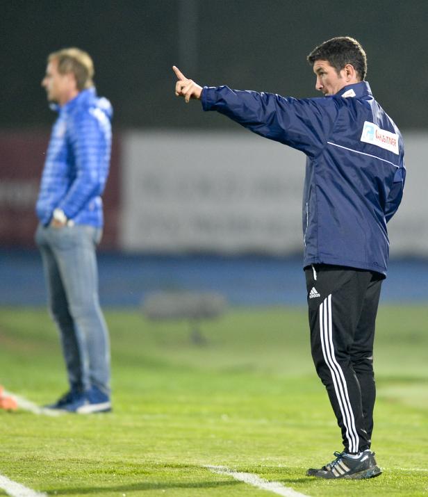 Ein Trainer in Sportkleidung gibt Anweisungen auf dem Spielfeld.