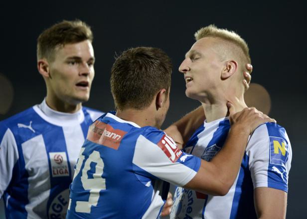 Fußballspieler umarmen sich während eines Spiels.