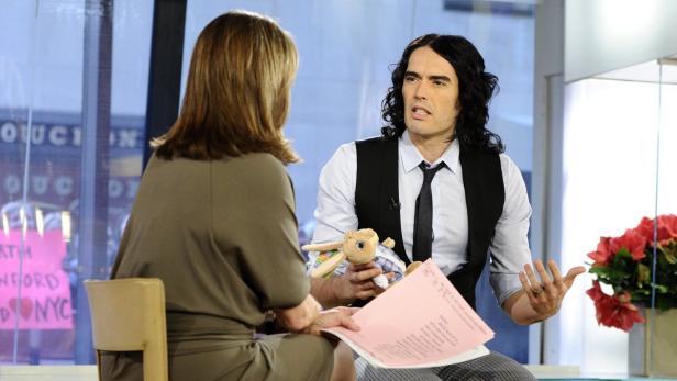 Russell Brand hält ein Stofftier während eines Interviews.