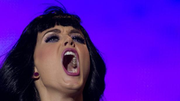 Eine Frau mit offenem Mund und dunklen Haaren vor einem violetten Hintergrund.