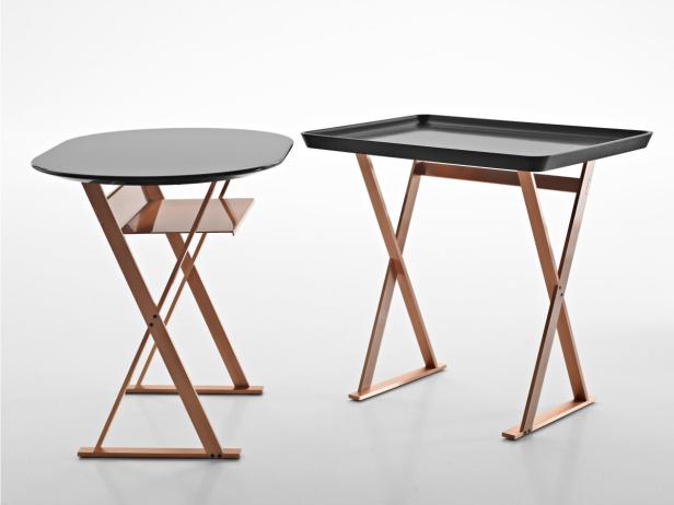 Zwei Beistelltische mit schwarzen Tischplatten und bronzefarbenen, kreuzförmigen Gestellen.