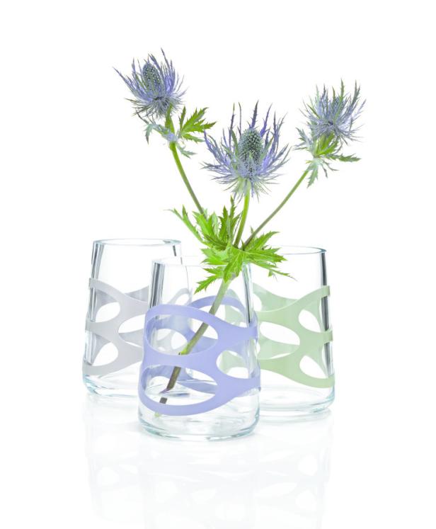 Drei Glasvasen mit farbigen Bändern und je einer blauen Distelblüte.