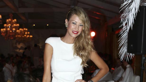 Eine Frau in einem weißen Kleid posiert auf einer Party.