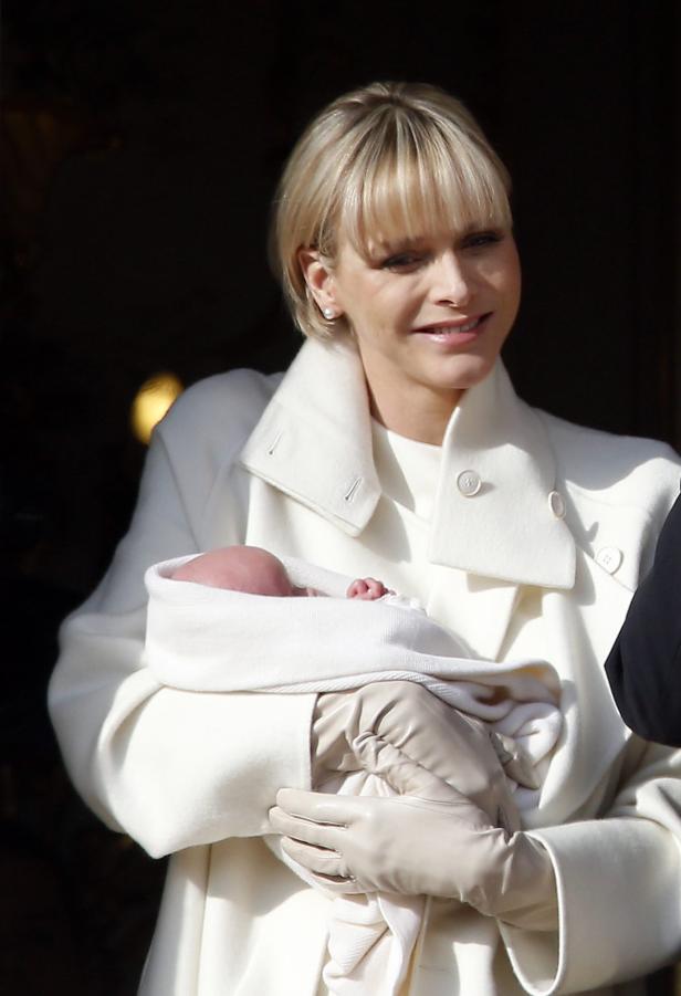 Fürstin Charlène von Monaco hält ein Baby im Arm.