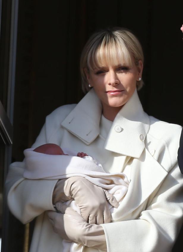 Fürstin Charlène von Monaco hält ein Baby im Arm.