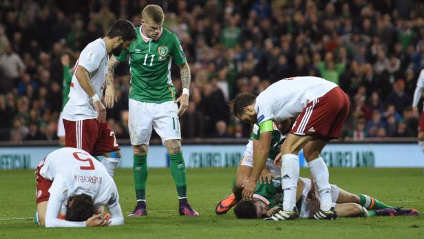 Während eines Fußballspiels liegt ein Spieler am Boden, umringt von besorgten Mitspielern.