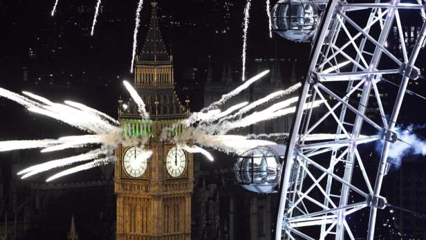 Feuerwerk explodiert hinter dem Big Ben und dem London Eye.