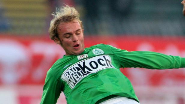 Ein Fußballspieler im grünen Trikot von Werder Bremen auf dem Spielfeld.