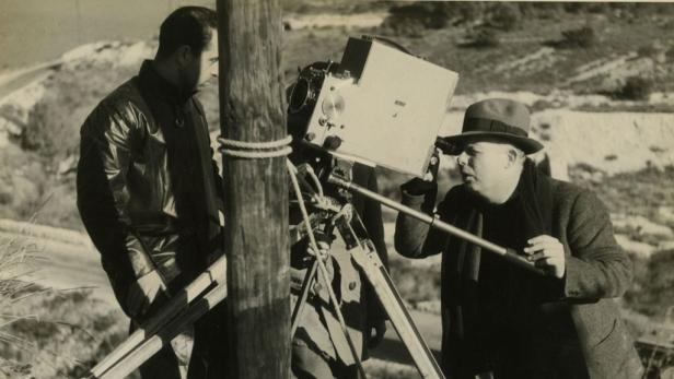 Zwei Männer filmen mit einer alten Filmkamera im Freien.